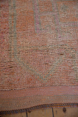 Textured pile and fringed end of distressed Kurd runner in pink and tangerine.