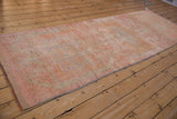 Short, even pile texture of the distressed vintage Kurd runner in pink and tangerine tones.
