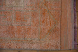 Distressed vintage Kurd runner pile and secured end in soft tangerine and blush tones.
