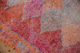 The nubby texture of the short, distressed pile in tangerine, fuchsia, and silver.