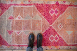 Distressed vintage Kurd runner showing primitive geometric patterns, fuchsia, copper, and silver tones.