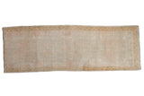 Distressed Oushak rug runner with faded gul medallions in pale pink, seafoam, and dusty gold.
