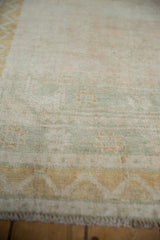 Close view of the distressed runner's even wear, showing a chevron border in dusty gold.
