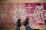 Close-up of vintage Kurd runner, heavily abrashed, showing fuchsia, blush, ivory geometric patterns.
