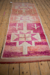Abrashed Kurd runner with geometric starburst medallion, primitive motifs, fuchsia and blush tones.