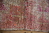 Heavily abrashed vintage Kurd runner texture, showing knot heads, fuchsia, ruby, and beige.