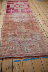 Distressed Kurd runner with heavily abrashed field, fuchsia and ivory geometric starburst patterns.