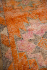 Distressed tangerine orange, pale fuchsia, and oxidized silver geometric Kurd runner pile.