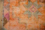 Textured pile of a distressed Kurd rug runner showing tangerine, oxidized silver, and fuchsia colors.
