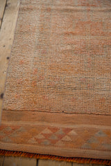 Even wear on distressed Kurd runner pile, blush and dusty red tones, geometric flatweave end.