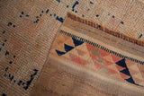 Close-up of distressed hand-knotted Kurd runner foundation and worn ivory pile with cobalt blue.