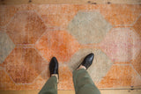 Distressed rug texture showcasing tangerine orange and slate blue panels.