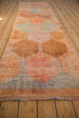 Distressed texture and faded tones on a vintage Kurd runner, showing lattice panels.