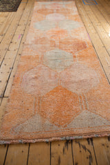 Distressed texture and secured side edge of the vintage Kurd runner in dusty tangerine.