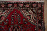 Corner of Dargezine runner showing blush, brown vine border and cherry red field.