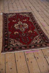Cherry red Dargezine runner with vibrant floral medallion and meandering leaf vine border.