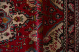 Folded edge of a vintage Dargezine runner, showing red, cream, and blue floral motifs.