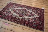 Vintage Dargezine rug corner with blush, black cherry red floral spandrel on ivory, dark navy borders.