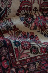 Close-up of hand-knotted Dargezine rug's pile, showing blush, black cherry, navy, and silver florals.