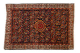 Vintage Serbend rug: navy blue Herati field, central orange octagon, and ornate boteh border.