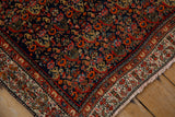 Corner of vintage Serbend rug, showing navy Herati field and beige boteh design border.