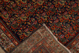 Vintage Persian Serbend rug corner showing hand-knotted foundation and navy Herati pattern.
