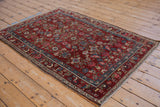 Fringed corner of the vintage Kurdish Hamadan rug showing floral border and geometric Herati.