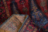 Hand knotted backweave and blue selvage of the Lilihan rug's matted raspberry red pile.