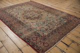 Antique Kerman rug's scalloped floral medallion and borders in cochineal red, ivory, dark navy.