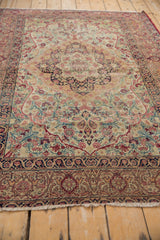 Antique Kerman rug's side border, featuring intricate dark navy and cochineal red floral vines.