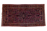 Vintage American Sarouk rug with a cherry red field, central medallion, and allover navy blue and ivory floral sprays.