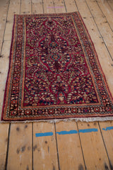 Angled view of a vintage Sarouk runner, showcasing the cherry red field with floral sprays and its full length.