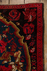 Corner detail showing the original side cord selvage and narrow red vine border of the Karabagh rug.