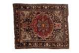Fine antique Farahan Sarouk square mat with ruby red medallion, navy field, floral vinery, ivory spandrels.
