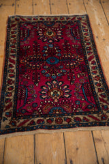 The plush, raspberry red pile of a vintage Lilihan rug showing detailed floral sprays and borders.