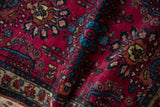 Plush, even pile of a vintage Lilihan rug with rich raspberry red and sapphire blue floral details.