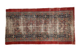 Antique Serab rug fragment with a worn floral center and a navy blue pawn design border surrounded by cherry red.