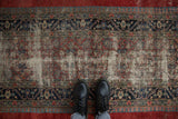 Detailed navy and red borders frame the heavily worn field of an antique Serab runner.