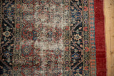 Worn pile revealing the foundation next to the pawn design border of an antique Serab rug.