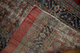 The hand-knotted reverse weave and wide red outer border of an antique Persian Serab fragment rug.