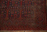 Lower edge of vintage Ersari rug, chestnut and navy guls, tattered fringe, visible foundation.