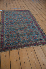 Vintage Lilihan rug corner detail, showing Veramin pomegranate lattice, sky blue, raspberry, and frayed ends.