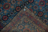 Vintage Lilihan rug folded, showing Veramin design of sky blue, raspberry, and its woven foundation.