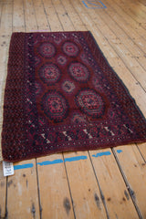 Vintage Turkmen rug's stylized border design in burgundy, fuchsia, navy, with evident wear and tatter.