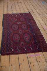Vintage Turkmen rug border detail: stylized patterns in burgundy, navy, fuchsia, with tattered fringe.