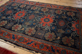 Antique Fine Senneh rug: navy, red, beige floral vinery, worn pile, fringed edges.