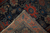 Antique Senneh rug's folded corner reveals navy, red, and beige patterns, foundation, and tattered fringe.