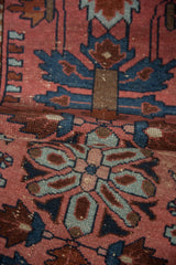 Folded detail of the hand-knotted Lilihan rug with dusty blush and sapphire blue floral palmettes.