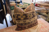 Close-up of vintage Turkish hand-knotted rug fragment pillow with geometric patchwork.