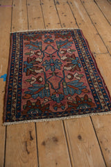 Vintage Mehriban rug detail with dusty raspberry low pile, fringe, and blue patterned border.